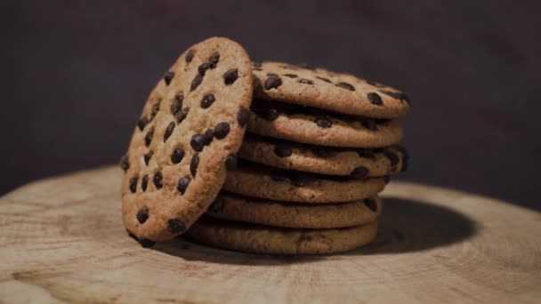 Cookie-k csokoládé morzsa, fából készült tábla, 360 fokos forgás. Gyönyörű sötét háttér. - Felvétel, videó