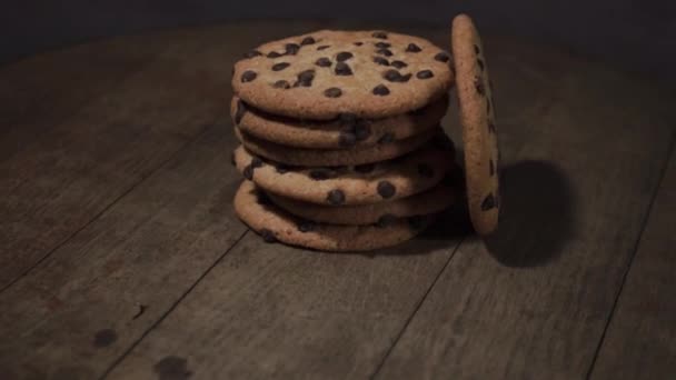 Biscotti con briciole di cioccolato su un tavolo di legno, rotazione 360 gradi. Bello sfondo scuro
. - Filmati, video