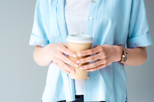 abgeschnittene Aufnahme einer Frau mit Pappbecher Kaffee isoliert auf grau - Foto, Bild