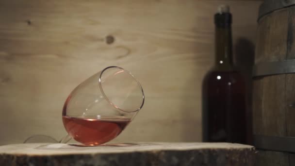 Bardak beyaz şarap bir turda, ahşap masa, rotasyon 360 derece kırık. Güzel ahşap varil ve şişe arka plan. - Video, Çekim