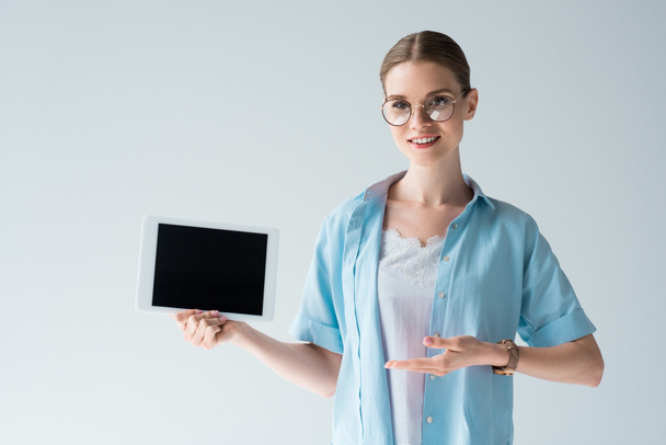 happy young woman showing tablet with blank screen isolated on grey - Photo, Image