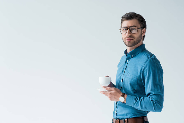 handsome young man with cup of coffee looking at camera isolated on white - Foto, imagen