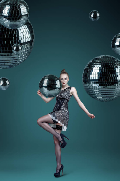 Young attractive woman with disco balls night club portrait - 写真・画像