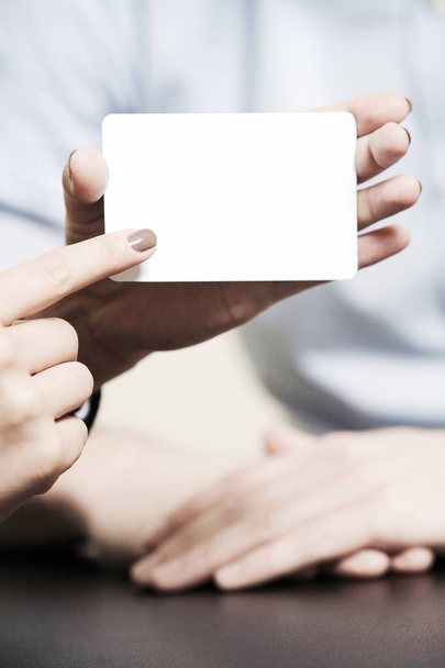 Бланк визитной карточки белый, женщина держит ее пальцами
 - Фото, изображение