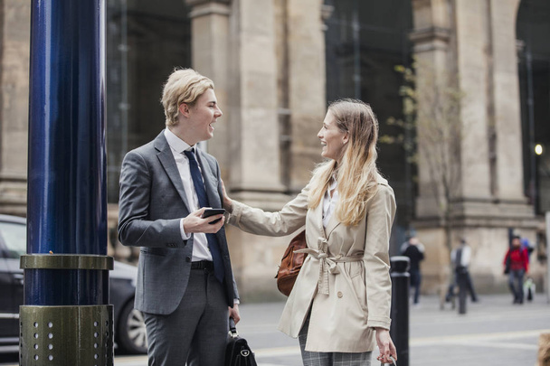 Businessman and businesswoman meeting up on the street to go to a meeting together. - Foto, Imagen