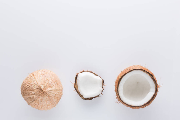 Tropikalny owoc w całości i pół abstrakcyjne tło .Kokos na białym tle. z góry widok - Zdjęcie, obraz