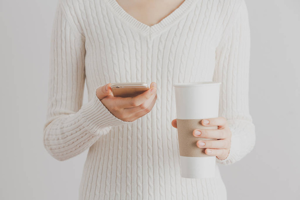 Soft focus young girl hands using smartphone and hold a cup of coffee. Copy space. Communication coffee break concept. - Foto, Bild