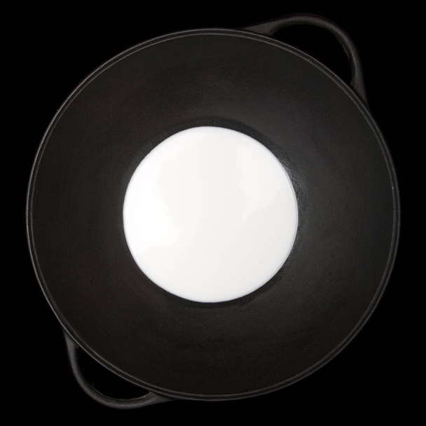 leche en un wok, fondo negro
 - Foto, Imagen