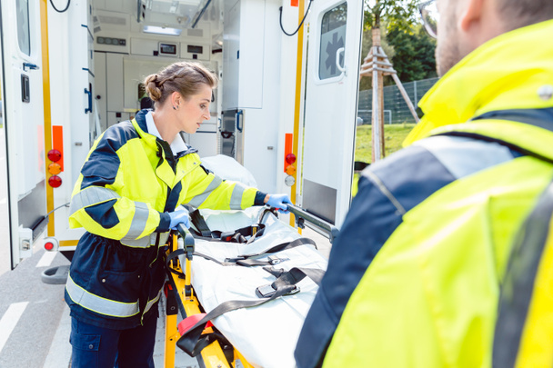 Paramédicos preparando camilla en ambulancia
 - Foto, imagen