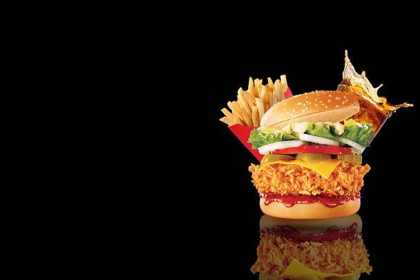 Grande cheeseburger único com copo de cola e batatas fritas em fundo preto. Espaço de cópia
 - Foto, Imagem
