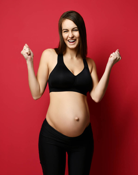 Young pregnant happy mother woman happy smiling on red - Foto, Bild
