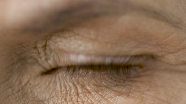 close up of blinking senior woman eye - Záběry, video
