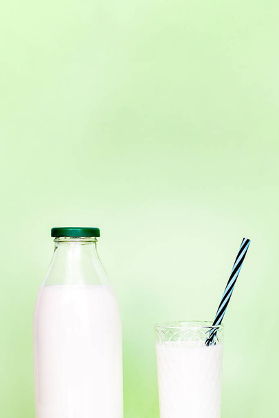Milk in a glass bottle and a transparent glass with straw  - Photo, Image