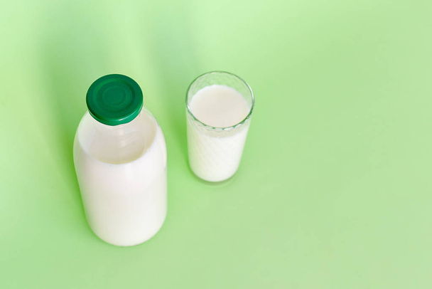 Milk in a glass bottle and a transparent glass with straw  - Fotoğraf, Görsel