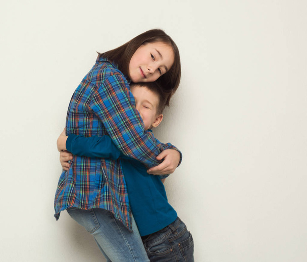 Happy brother and sister hug, studio background - Fotografie, Obrázek