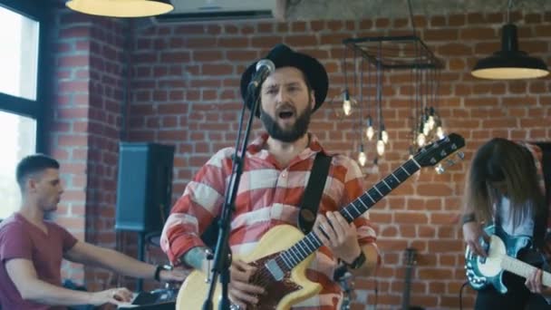Эмоциональный бородатый гитарист поет в микрофон
 - Кадры, видео