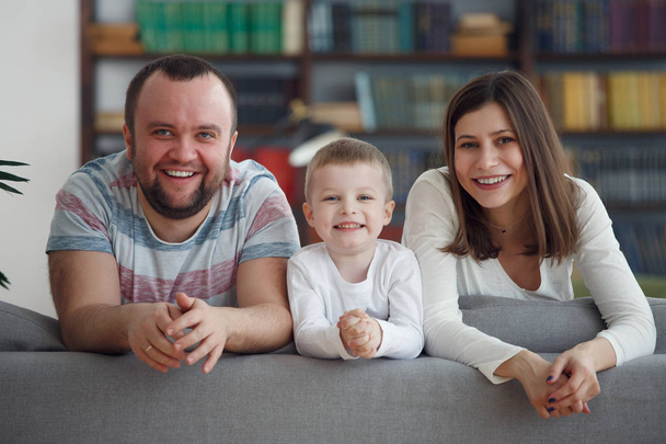 Foto de padres con niños en sofá gris
 - Foto, Imagen