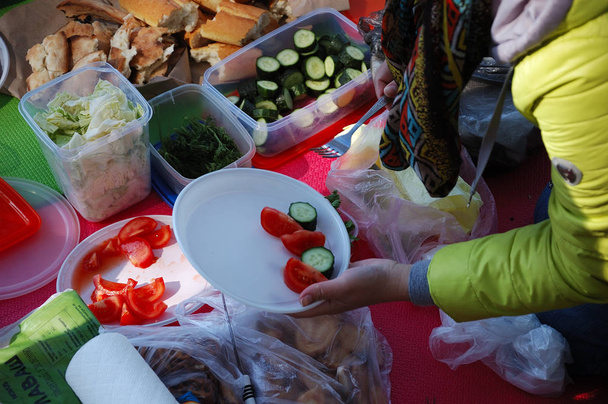 La gente su un picnic mette il cibo su piatti - una vista dall'alto
. - Foto, immagini