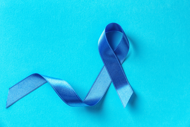 Blue ribbon on color background. Prostate cancer concept - Photo, image
