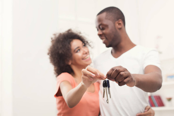 Feliz pareja negra sosteniendo las llaves de su nuevo hogar
 - Foto, Imagen
