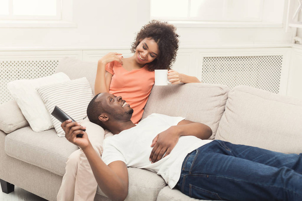 Happy african-american couple watching TV at home - Zdjęcie, obraz