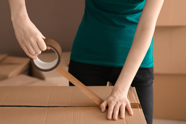 Woman packing carton box indoors. Moving house concept - Fotografie, Obrázek