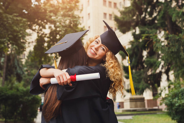 Ζευγάρι μαθητών που αγκαλιάζει την ημέρα της αποφοίτησης τους - Φωτογραφία, εικόνα