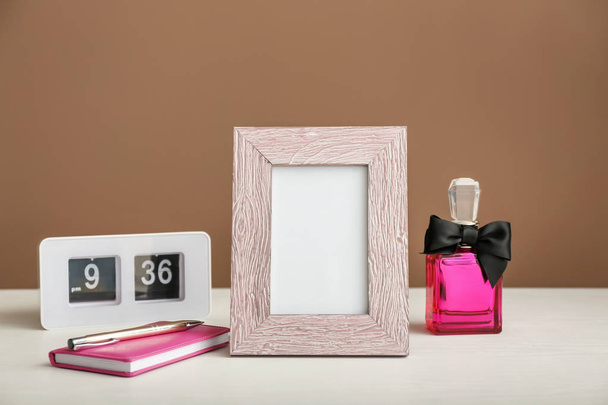 Composition with photo frame on white table against color background - Photo, Image