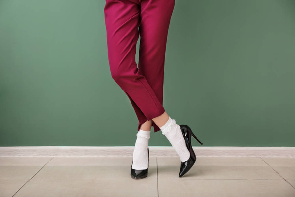 Ноги красивої молодої жінки, що стоїть на кольоровій стіні
 - Фото, зображення