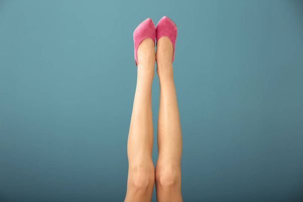 Legs of beautiful young woman on color background - 写真・画像