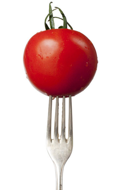 fresh tomato on an old silver fork  - Foto, immagini