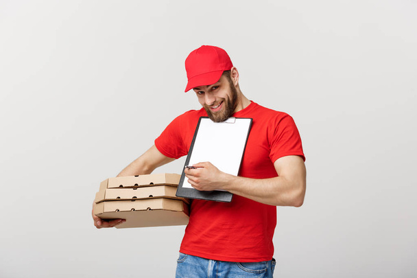 Delivery Concept: Young handsome delivery man with pizza boxes giving you a document to sign - Photo, Image