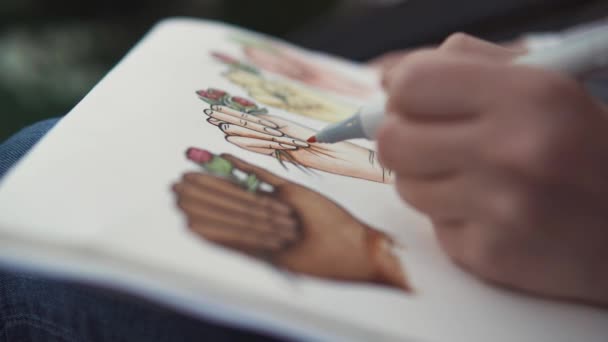 Zbliżenie: proces rysowania szkiców, ręka trzyma pisaki i malarstwo - Materiał filmowy, wideo