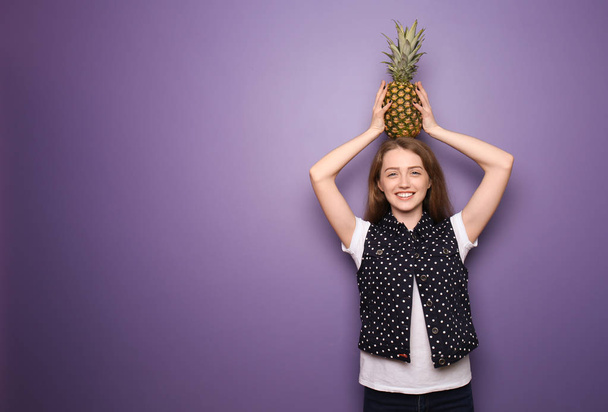 Portrait of beautiful young woman with pineapple on color background - Fotó, kép