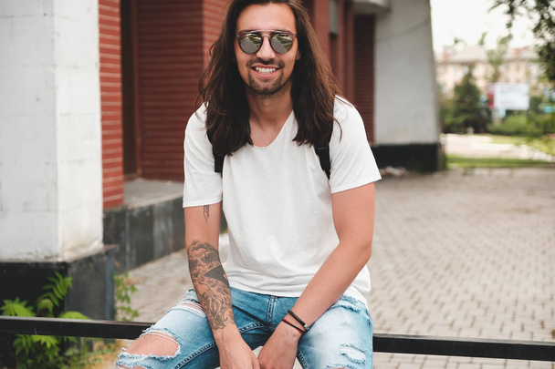 Portré vonzó férfi napszemüveg a városi hátterű smil - Fotó, kép