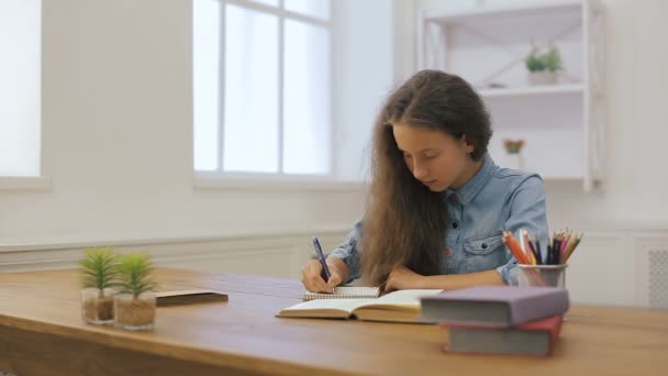 Jong meisje met laptopcomputer doet huiswerk. Onderwijs van de Universiteit. Vrouwelijke student studeert thuis. - Video