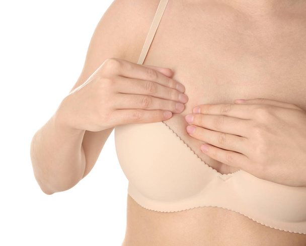 Nainen tutkii rintaansa valkoisella pohjalla, lähikuva. Syöpätietoisuuden käsite
 - Valokuva, kuva