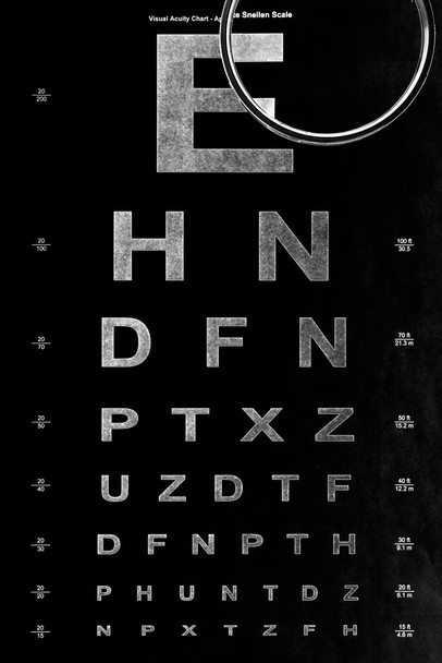 eye test chart and magnifying glass - Foto, afbeelding