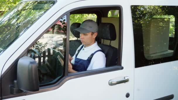 Uomo di consegna digitando sul tablet digitale senza lasciare il furgone
 - Filmati, video