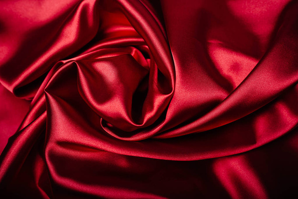 Red fabric in the folds. drapery. shine on silk. Sewing - Photo, Image
