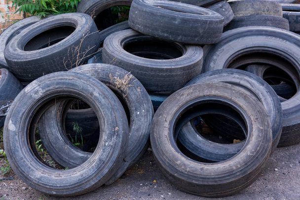 vanhat kuluneet renkaat ovat iso kasa kaatopaikalla
 - Valokuva, kuva