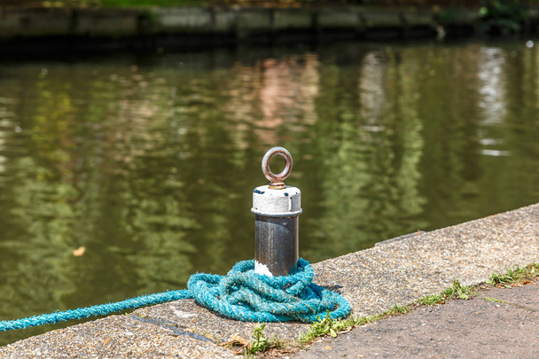 Pequena amarração com uma corda azul em um pequeno rio na Inglaterra, Norwich
 - Foto, Imagem