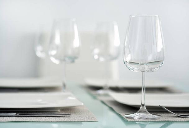 Table setting with a wine glasses, cutlery and plates - Photo, image