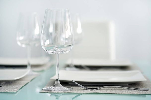 Table setting with a wine glasses, cutlery and plates - Photo, image