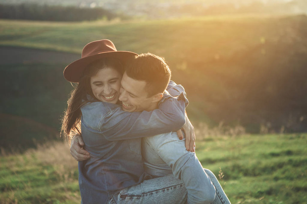 Loving young people hugging on green hill - Фото, изображение