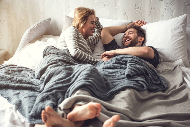 Carefree couple is having fun while staying in bed - Fotoğraf, Görsel