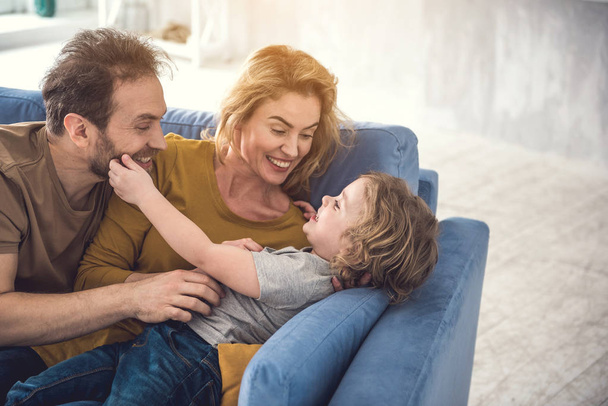 Embracing parents are entertaining son indoors - Fotografie, Obrázek