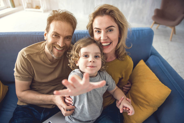 Joyful couple is spending time with kid in domestic atmosphere - Photo, Image