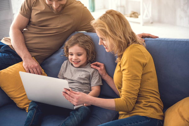 Happy family is using laptop at home - Fotó, kép