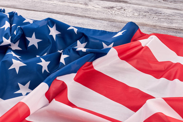 Crumpled flag of USA on wooden background. - Foto, afbeelding